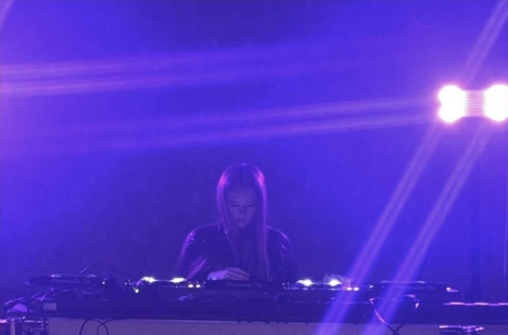 An EQ Lab student DJing a live set under purple stage lights